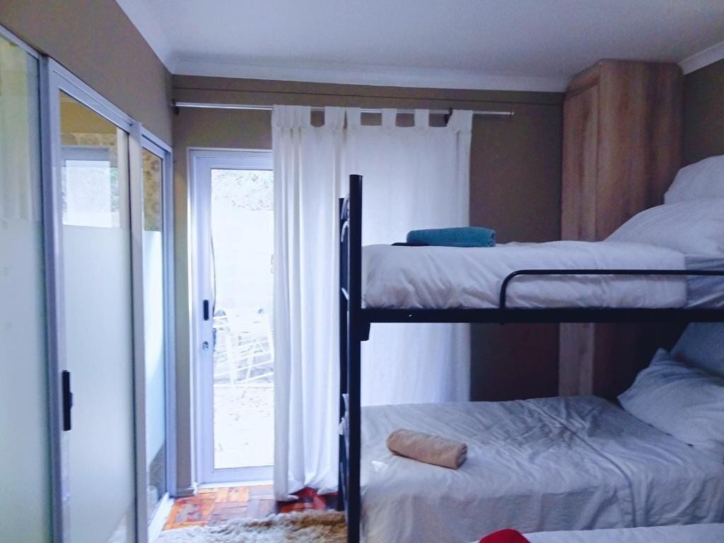 A bunk bed room with a sliding glass door leading to a balcony.