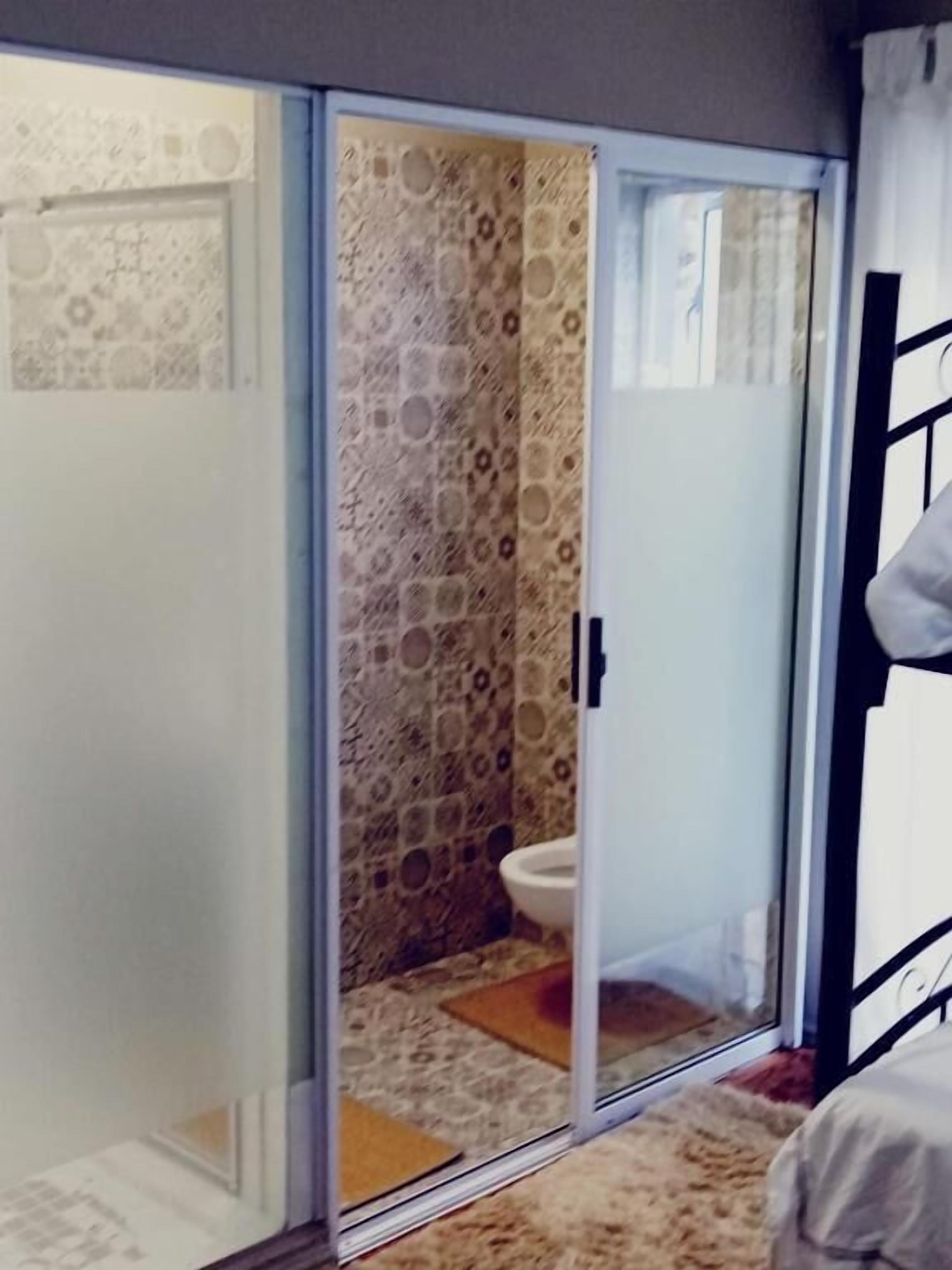 Familie vierpersoonskamer | Badkamer | Een douche, handdoeken, zeep, toiletpapier