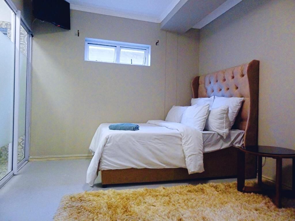 Una camera da letto con un letto, una finestra, una televisione e un tavolino.