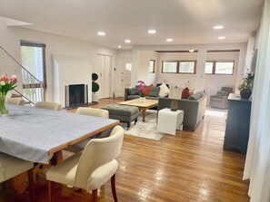 Un amplio salón con una mesa de comedor, sofás y una televisión.