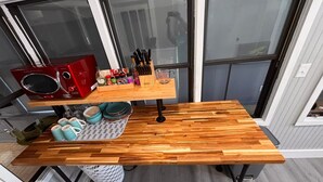 A kitchen with a wooden countertop, a red microwave, and various kitchen utensils. - Belmont King Studio - Walk Everywhere - Pet Friendly (Pensacola)