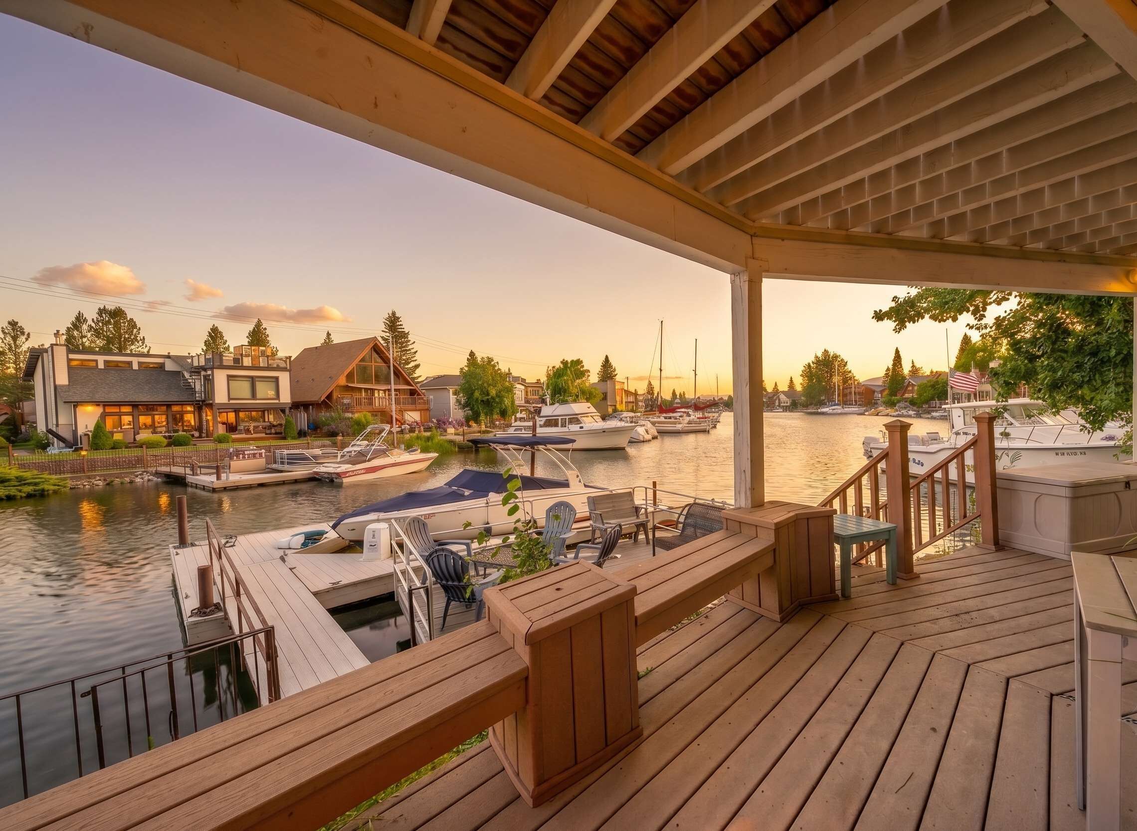A wooden deck with a view of a marina and houses.