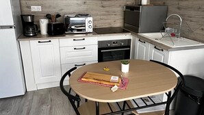 A compact kitchen with a microwave, toaster, coffee maker, and a sink. - Quiet and convenient apartment (Évaux-les-Bains)
