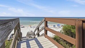 A wooden staircase leading to a beach with umbrellas and people. - Dune Villas #4A (Santa Rosa Beach)