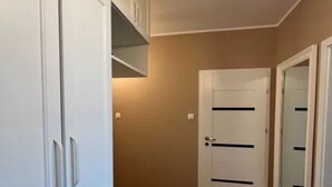 A hallway with a wardrobe, a door, and a light fixture.