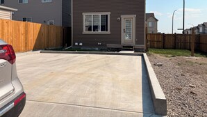 A two-story residential building with a driveway and a wooden fence. - Luxury 4BR Calgary Home|Families| Sleeps 8|AC& Free Parking & WiFi|Near Airport| (Calgary)