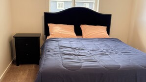 A bedroom with a bed, a nightstand, and a window. - Luxury 4BR Calgary Home|Families| Sleeps 8|AC& Free Parking & WiFi|Near Airport| (Calgary)