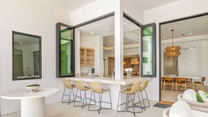 Una cucina moderna con isola centrale, arredamento open space e zona pranzo con sedie e tavolo.