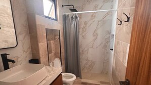 Een badkamer met een wastafel, toilet en douche.