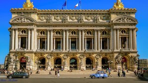 Ein prachtvolles Gebäude mit klassischer Architektur, mit Säulen, Statuen und aufwendigen Verzierungen.