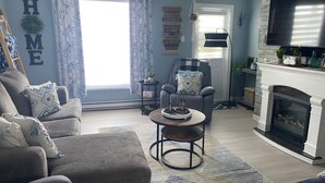 A living room with a fireplace, a sofa, a coffee table, and a television.