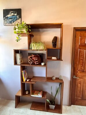 Ein mehrstufiges Regal aus Holz mit verschiedenen Dekorationen und Pflanzen.