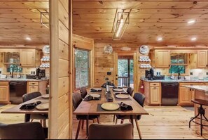 Ein Holzblock mit Esszimmer, Stühlen, Küchenzeile und Holzschränken.
