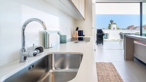 A modern kitchen with a stainless steel sink, a knife block, and a view of the outdoors. - Vibrant Marina Luxury Apartment in Lagos (Lagos)