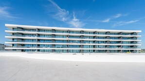 A modern multi-story building with a flat roof and large windows. - Vibrant Marina Luxury Apartment in Lagos (Lagos)