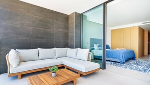 A modern room with a sectional sofa, a wooden coffee table, and a bed with a blue bedspread. - Vibrant Marina Luxury Apartment in Lagos (Lagos)