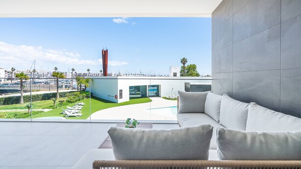 A modern interior with a view of a marina, a white sofa, and a glass wall. - Vibrant Marina Luxury Apartment in Lagos (Lagos)