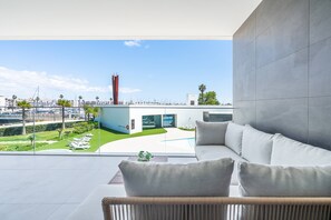 Un intérieur moderne donnant sur une marina, avec un canapé blanc et un mur en verre.