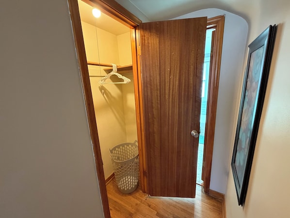 A hallway with a wooden door, a laundry basket, and a framed picture on the wall. - Private apartment suite in Omaha! (Omaha)