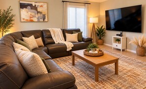 A living room with a leather sofa, a coffee table, a TV, and a lamp. - Private pool retreat , walk to Sabino Canyon (Tucson)
