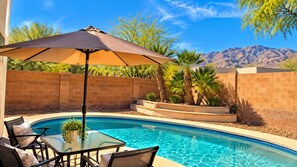 A swimming pool with a glass table and chairs, surrounded by a brick wall and palm trees. - Private pool retreat , walk to Sabino Canyon (Tucson)