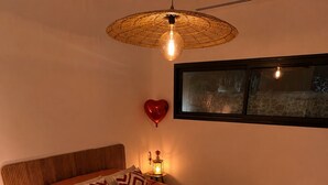 A bedroom with a bed, a heart-shaped decoration on the bed, a hanging light fixture, and a wall-mounted picture. - The River's Cocoon (Saint-Drézéry)