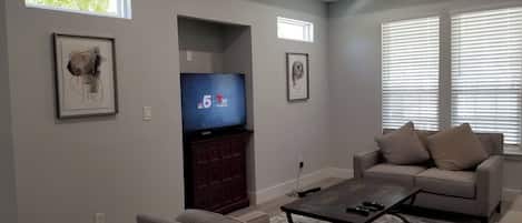 A living room with a television, sofa, and coffee table.