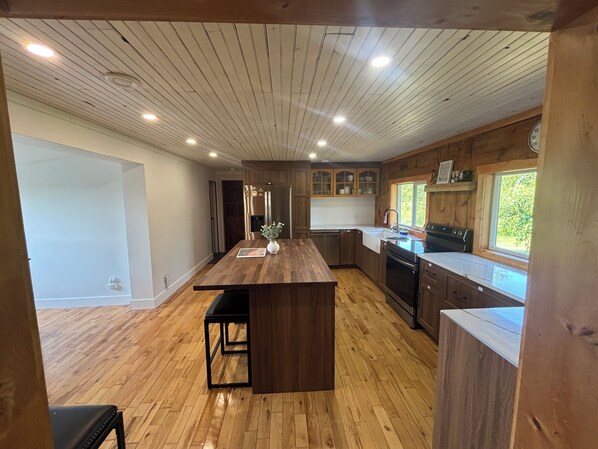 Una cocina moderna con suelo de madera, una isla central y armarios empotrados.