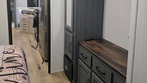 A compact kitchen with a built-in stove, a microwave, and a refrigerator. - New RV Sleepy Owl ,2-bedroom, 2 bathroom, 1 mile from lake Somerville. (Somerville)