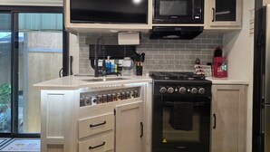 A kitchen with a built-in microwave, stove, and oven. - New RV Sleepy Owl ,2-bedroom, 2 bathroom, 1 mile from lake Somerville. (Somerville)