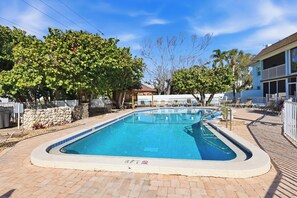 A rectangular swimming pool with a tiled edge, surrounded by a paved deck. - Recently Renovated 2bd/2ba a block from the beach & steps from the pool on AMI (Holmes Beach)
