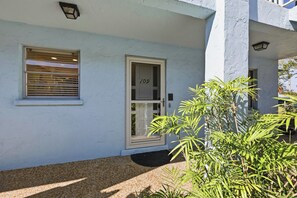 A building with a white exterior, a door marked with the number 109, and a window with blinds. - Recently Renovated 2bd/2ba a block from the beach & steps from the pool on AMI (Holmes Beach)