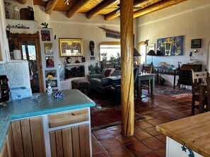 A rustic interior with a kitchen area, dining space, and a living room. - Marveloushouse in charming Ranchos de Taos (Ranchos de Taos)