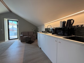 A modern kitchen with a built-in oven, microwave, and coffee maker. - Terra Vivaz - Porto Bay Formosa Suite (Porto Formoso)