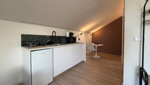Cuisine moderne équipée d’un lave-vaisselle, d’un four à micro-ondes et d’une machine à café. Un coin repas avec une table et des chaises est également à disposition.