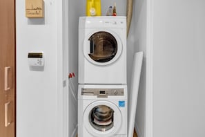 A stacked washer and dryer unit with a Toronto sign on the wall. - Maple Square Hotel (Toronto)
