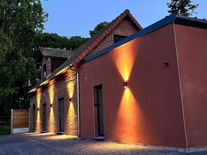 Un edificio con fachada de ladrillo y una extensión moderna con techo plano.