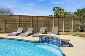 A swimming pool with lounge chairs, a wooden fence, and a clear sky. - Coastal Retreat with Private Pool - Minutes from 30A Beaches (Santa Rosa Beach)