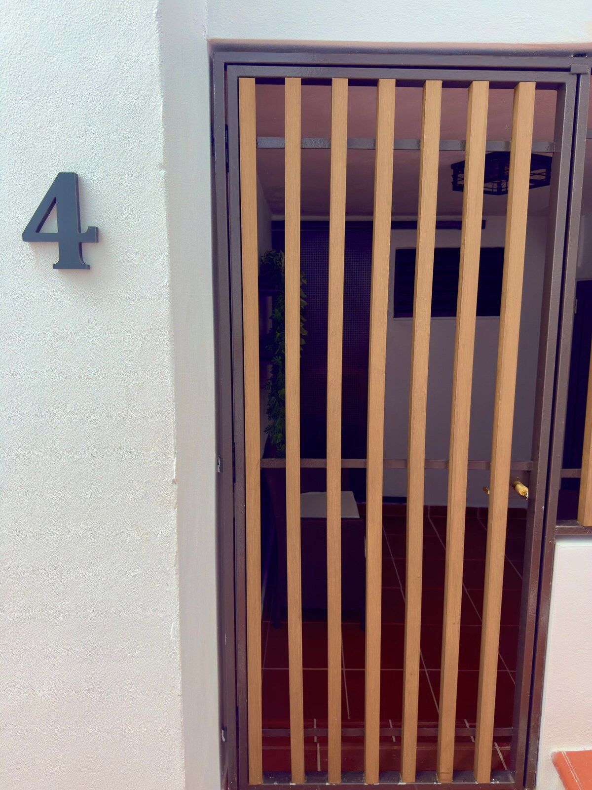 Une porte avec un portail de sécurité en métal et le chiffre « 4 » peint sur le mur.