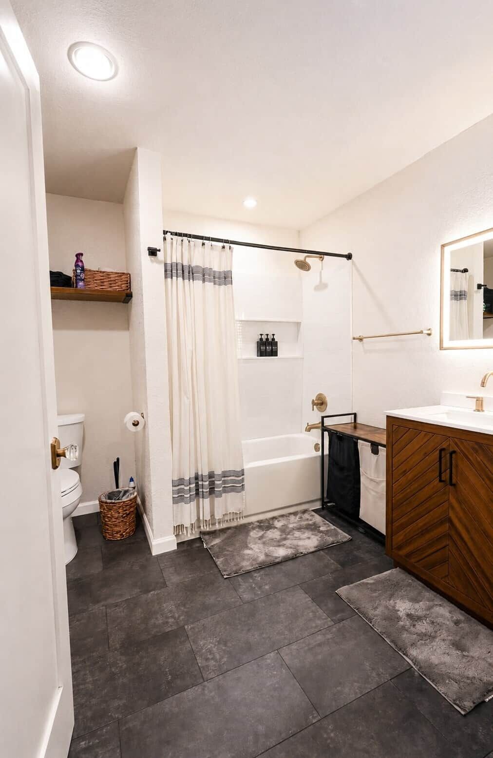 A bathroom with a shower, toilet, and vanity.