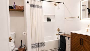 A bathroom with a shower, toilet, and vanity.