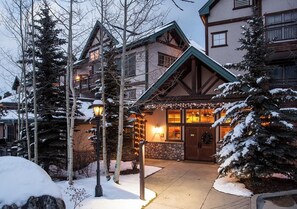 Eine Lodge mit einer Steinaußenseite, Holzverzierungen und einem beleuchteten Eingang.