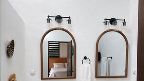 Une salle de bain avec deux lavabos, un miroir et un porte-serviettes.