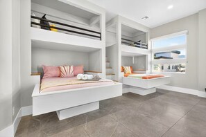 A modern bedroom with bunk beds, a large window, and a view of the outside. - 24 Guests l Private Pool/Spa l Mansion (Hurricane)