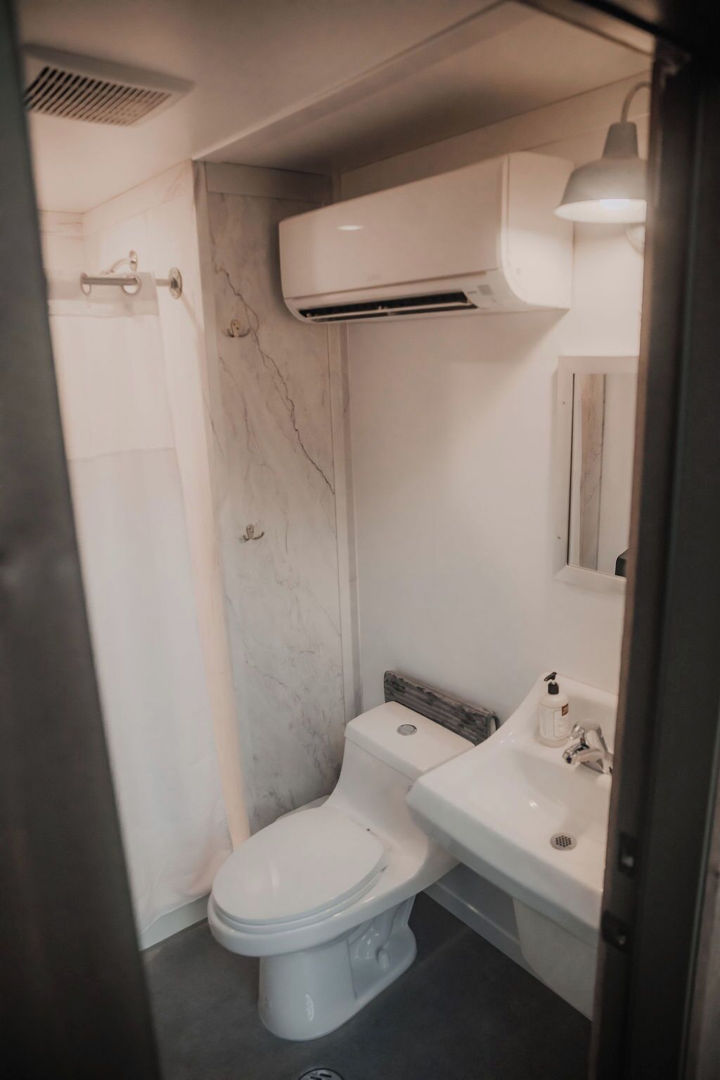 Un baño con inodoro, lavabo y ducha.