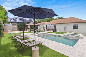 A backyard with a swimming pool, lounge chairs, and umbrellas. - Hail to the Beach on West 30A | Private Pool | Golf Cart | Walk to Beach (Santa Rosa Beach)