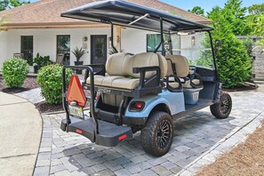 A golf cart parked on a driveway with a house in the background. - Hail to the Beach on West 30A | Private Pool | Golf Cart | Walk to Beach (Santa Rosa Beach)