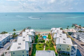 A resort with multiple buildings, a swimming pool, and a beach view. - Barefoot Paradise-Private Beach and Pool (Key Colony Beach)