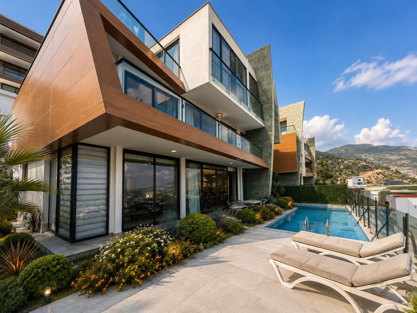 A modern multi-story house with a swimming pool, outdoor seating, and a view of the landscape.