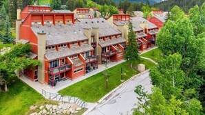 Ein mehrstöckiges Hotel mit Balkonen, eingebettet in eine gebirgige Landschaft mit grüner Umgebung.